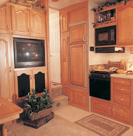 The 29.5 RLBG in Sand Decor. Full AM/FM/CD/Cassette Stereo System and color TV make up the home style entertainment center. Raised panel, residential cabinetry highlights the kitchen.