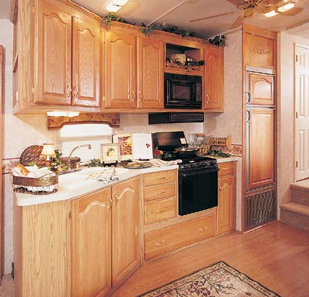 The 34.5 RLTG in Spice Decor. Great kitchen design with lots of storage and countertop space, oversize drawer underneath stove for pots and pans, and optional woodgrain laminate flooring.