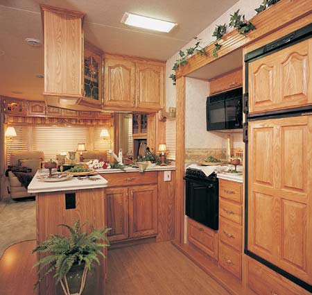 This 35 Quad Glide, in Dream Green designer decor, features lots of counterspace, storage, large double door refrigerator with raised panel front, optional wood grain laminate flooring, and a microwave oven.